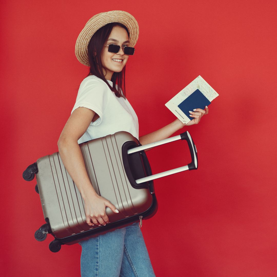 Happy female traveler with suitcase on red background-Parent visa (subclass 103)